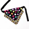 Golden Retriever wearing a colorful handmade polka dot pet bandana with tassel lace trim on a clean white studio background.